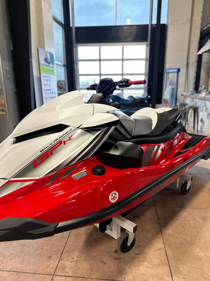 Slide: The Image of 2025 Yamaha WaveRunner GP HO in showroom, red and white design, side view. - 2