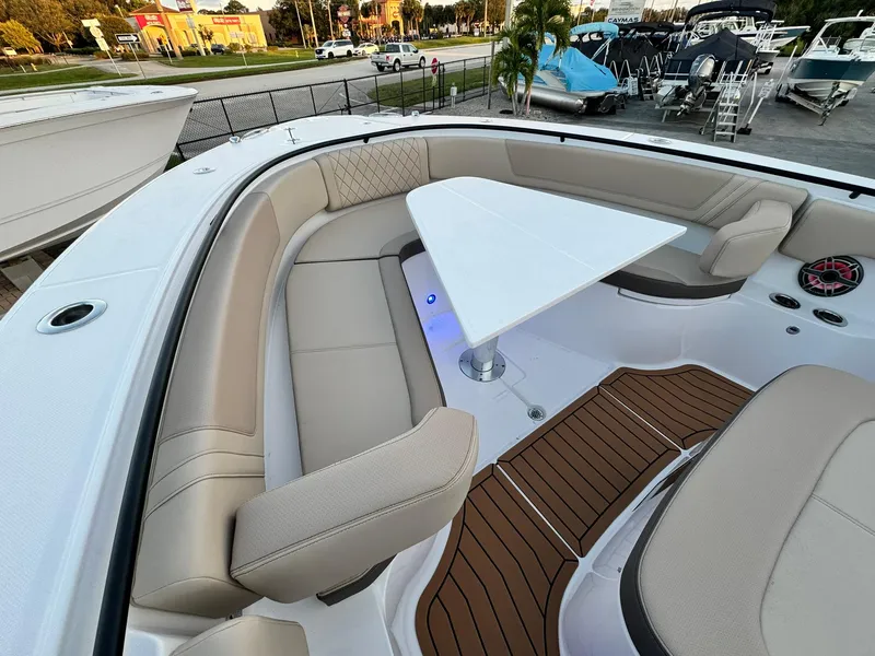 Slide: The Image of Luxurious seating area on 2025 Edgewater 370 CC boat with modern table and wood accents. - 27