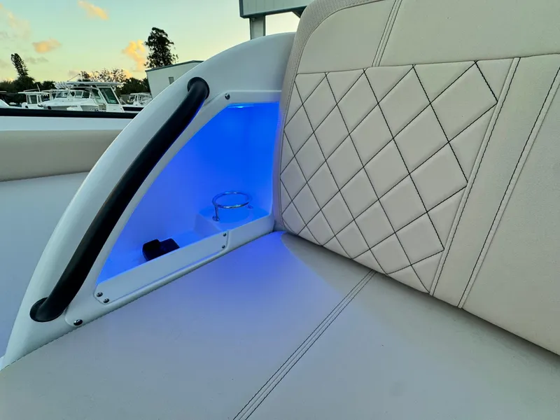 Slide: The Image of Edgewater 370 CC 2025 boat interior with blue LED lighting and quilted seating. - 31