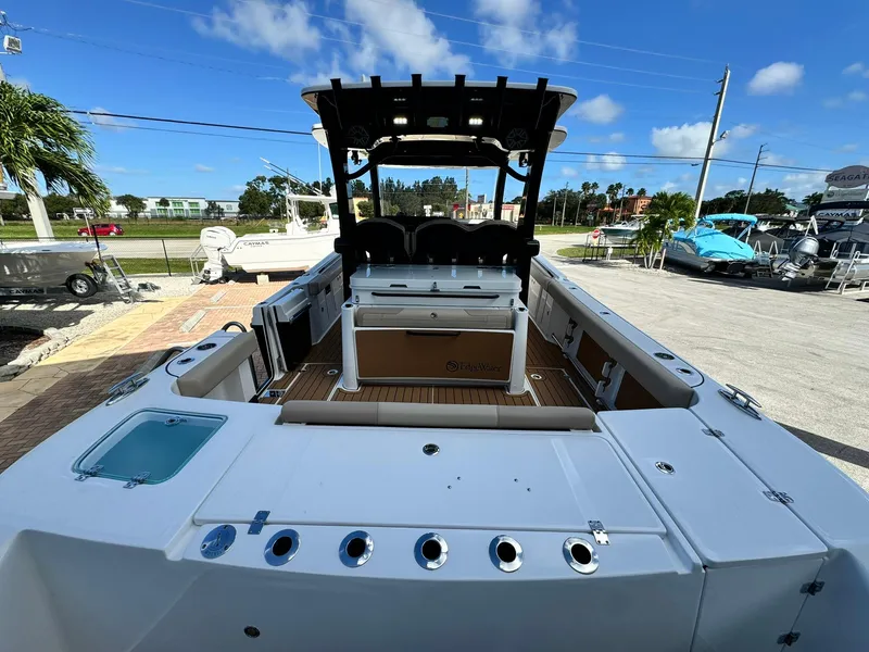 Slide: The Image of 2025 Edgewater 370 CC boat, spacious deck, modern design, outdoor setting, clear blue sky. - 4