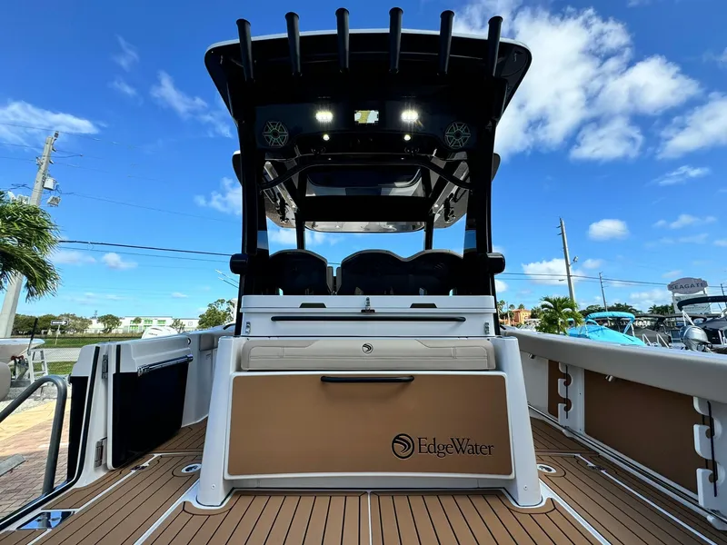 Slide: The Image of 2025 Edgewater 370 CC boat, rear view, showcasing deck and seating under clear blue sky. - 5