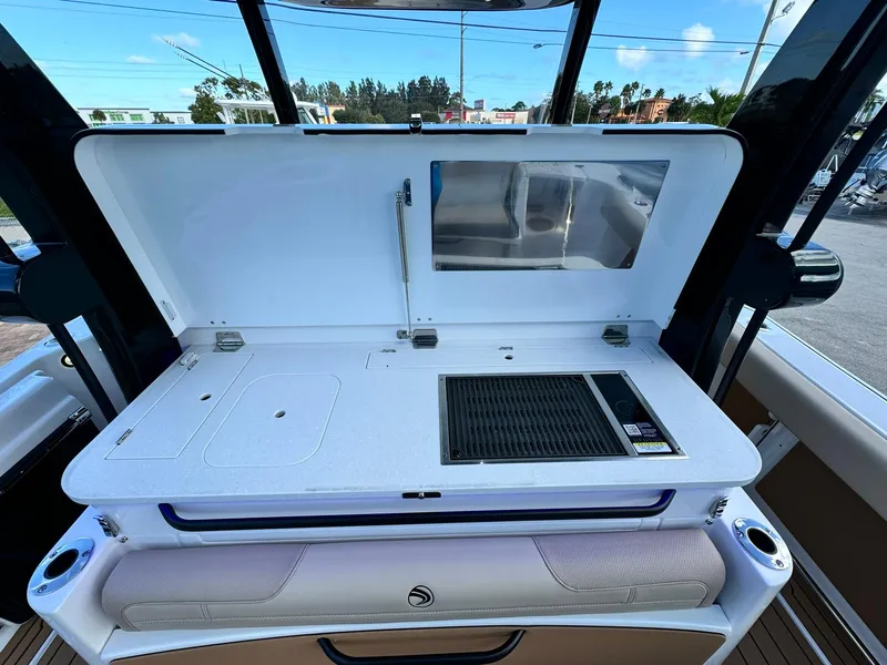 Slide: The Image of 2025 Edgewater 370 CC boat interior with open storage and grill area. - 9