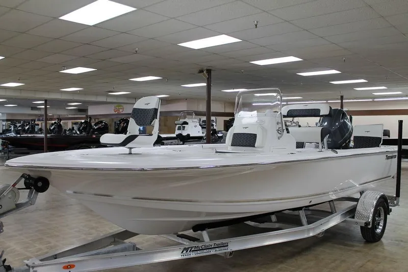 Slide: The Image of 2025 Tidewater 1910 BM boat displayed indoors on a trailer. - 2