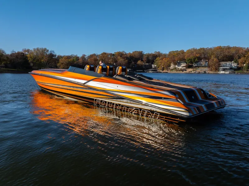 The Image of 2020 Fountain 47 Lightning speedboat with vibrant orange and black design on a calm lake. - 0