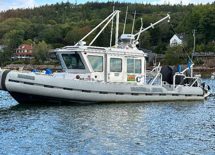 Slide: The Image of 2005 SAFE Boats Defender 25 on water, surrounded by trees and houses. - 1