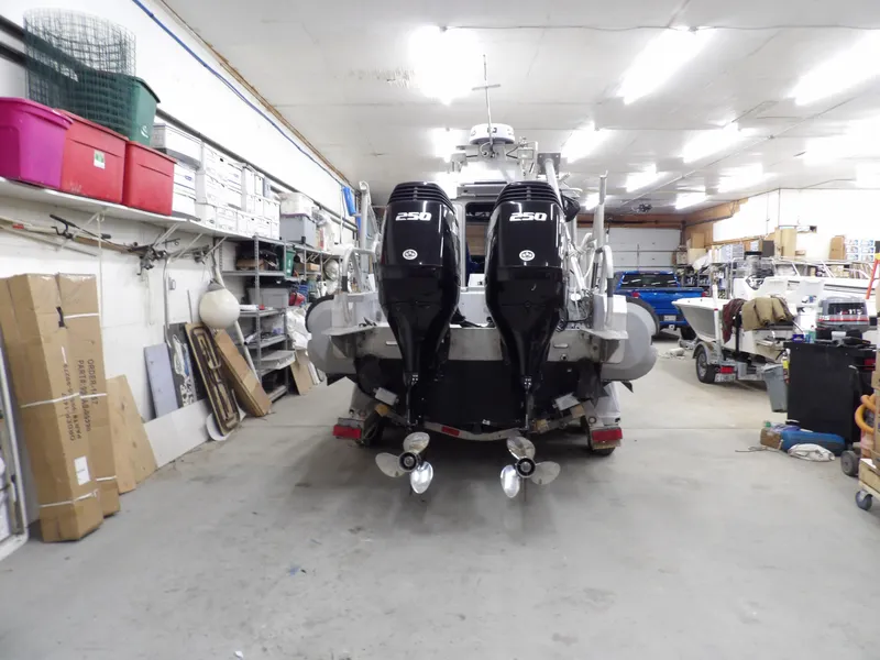 Slide: The Image of 2005 SAFE Boats Defender 25 in a garage with dual 250 engines. - 14