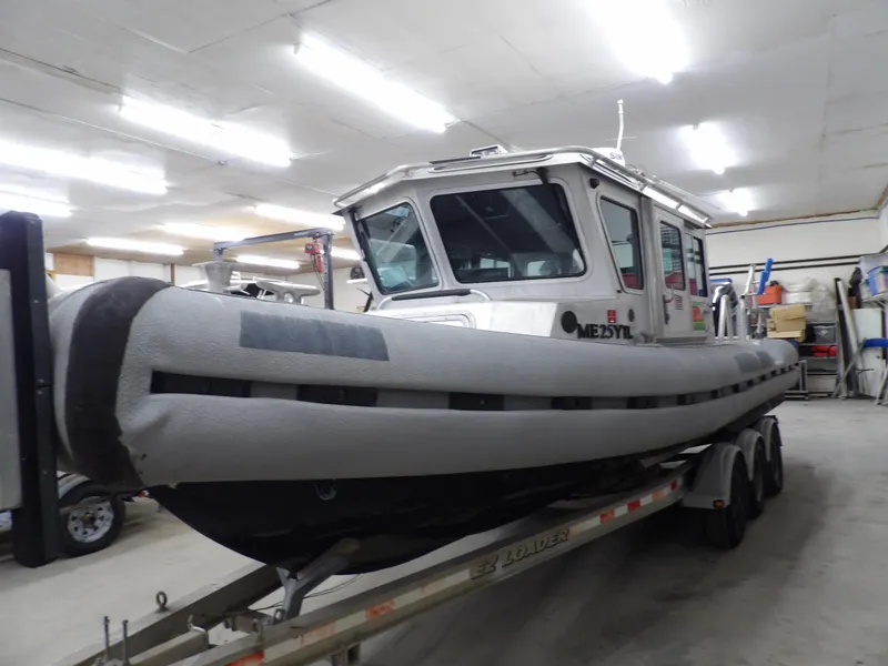 Slide: The Image of 2005 SAFE Boats Defender 25 on trailer in a garage. - 19