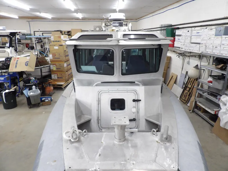 Slide: The Image of 2005 SAFE Boats Defender 25 in a workshop, surrounded by tools and boxes. - 22