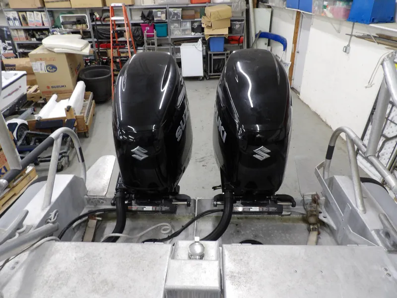 Slide: The Image of Twin Suzuki outboard engines on a 2005 SAFE Boats Defender 25 in a workshop. - 26