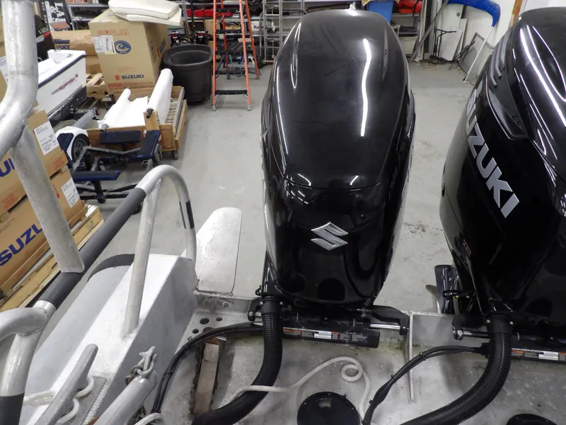Slide: The Image of Twin Suzuki outboard motors on a 2005 SAFE Boats Defender 25 in a workshop. - 28