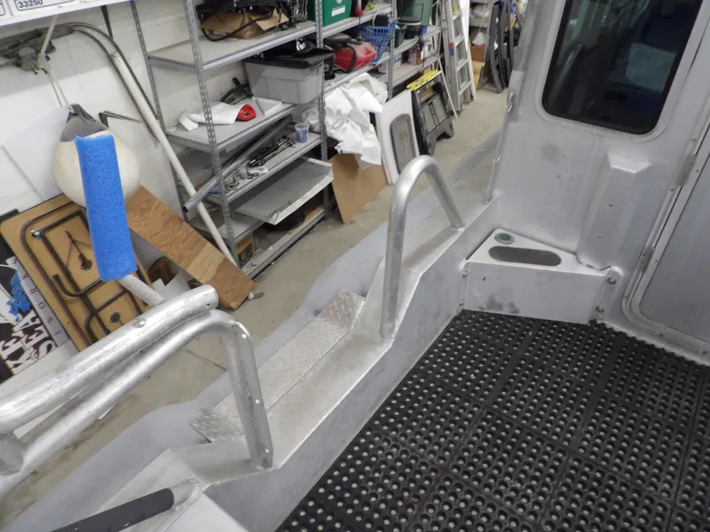 Slide: The Image of Interior of a 2005 SAFE Boats Defender 25 with metal railings and rubber flooring. - 44