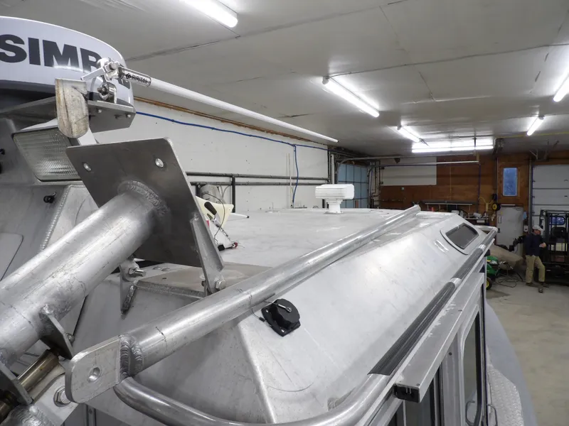 Slide: The Image of 2005 SAFE Boats Defender 25 in a garage, showcasing roof and equipment. - 49