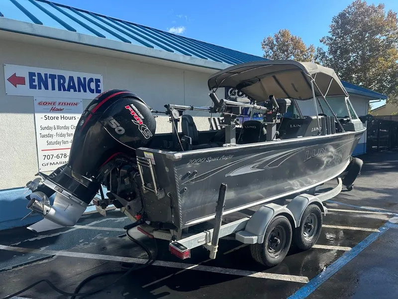 Slide: The Image of 2019 Lund 2000 Sport Angler boat on trailer, parked near entrance. - 14