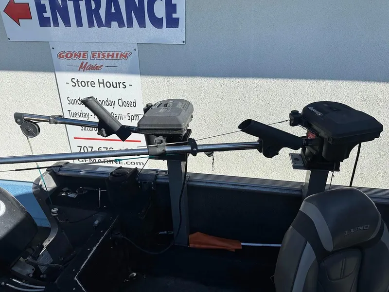 Slide: The Image of 2019 Lund 2000 Sport Angler boat interior with fishing equipment and store sign. - 21