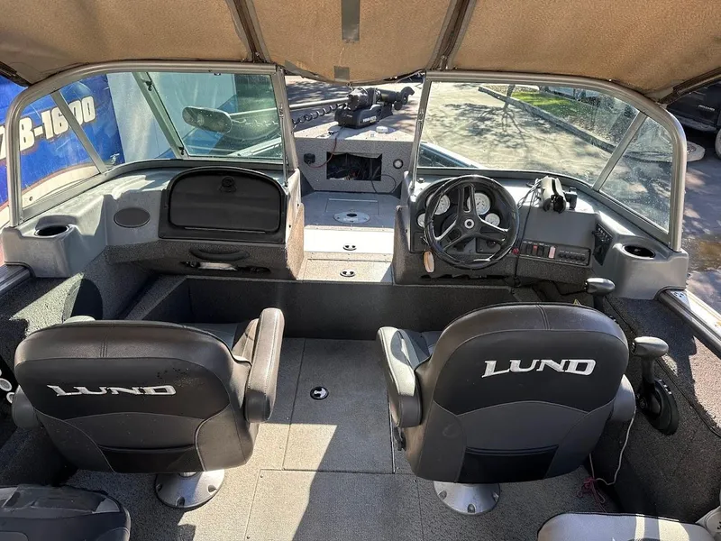 Slide: The Image of 2019 Lund 2000 Sport Angler boat interior with steering wheel and seating. - 25