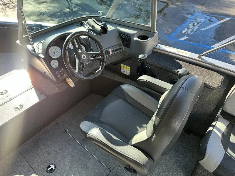 Slide: The Image of 2019 Lund 2000 Sport Angler boat interior with steering wheel and seating. - 27