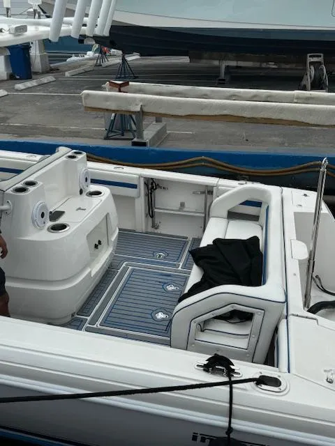 Slide: The Image of 2008 Intrepid Open boat interior at dock, featuring seating and storage areas. - 8