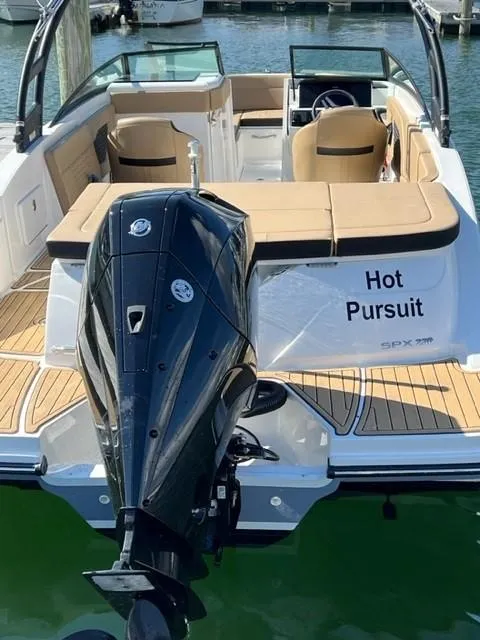 Slide: The Image of 2023 Sea Ray SPX 230 OB boat with "Hot Pursuit" name, docked in marina. - 1