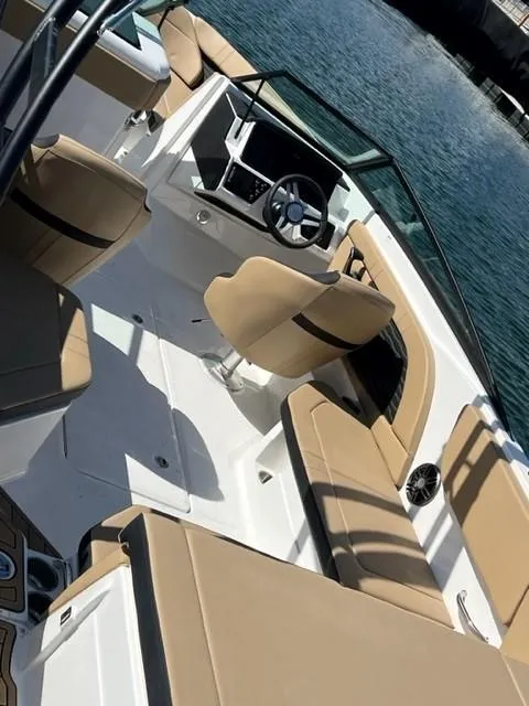 Slide: The Image of 2023 Sea Ray SPX 230 OB boat interior with tan seating and steering console. - 3
