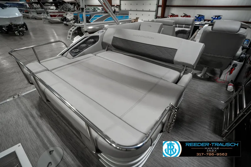 Slide: The Image of 2022 Bennington 22 LSB pontoon boat interior with plush seating in showroom. - 26