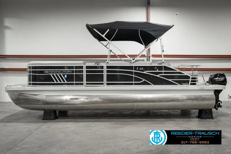 Slide: The Image of 2022 Bennington 22 LSB pontoon boat with black canopy in showroom. - 4
