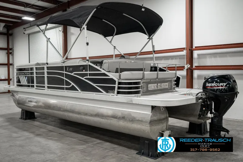 Slide: The Image of 2022 Bennington 22 LSB pontoon boat with canopy in a warehouse setting. - 6