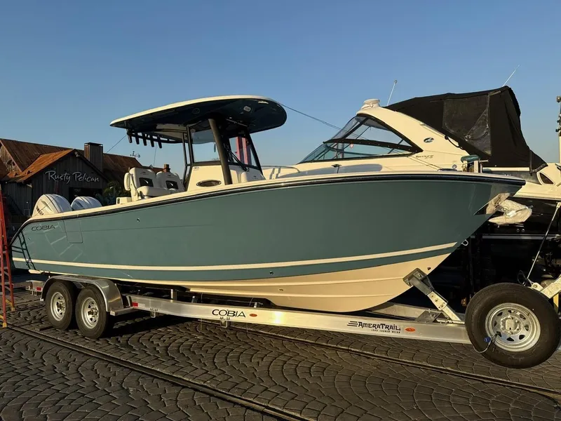 The Image of 2025 Cobia 265 Open Center Console boat on trailer, side view. - 0