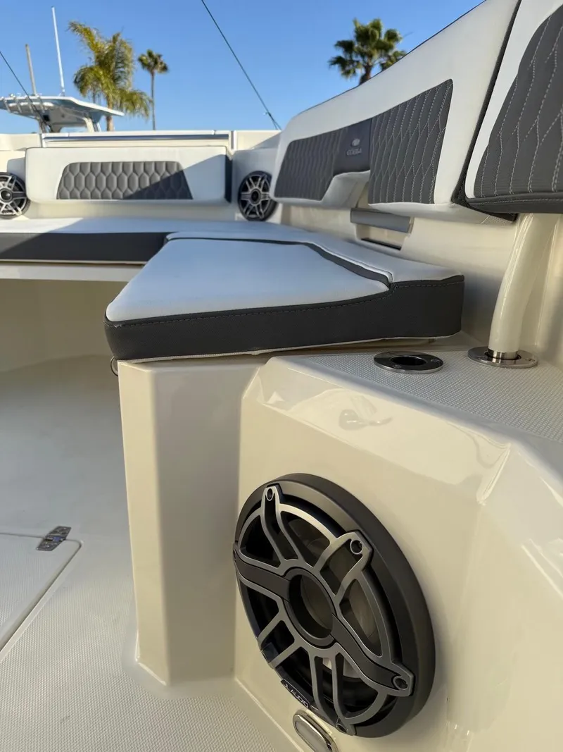 Slide: The Image of 2025 Cobia 265 Open Center Console boat interior with cushioned seating and speaker. - 13