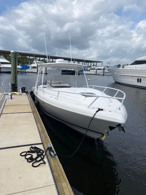 The Image of 2008 Intrepid 327 Cuddy boat docked at marina under cloudy sky. - 0
