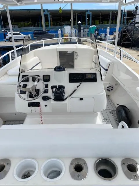 Slide: The Image of 2008 Intrepid 327 Cuddy boat cockpit with steering wheel and control panel. - 2