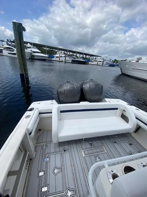 Slide: The Image of 2008 Intrepid 327 Cuddy boat docked in marina, featuring dual engines and spacious seating. - 5