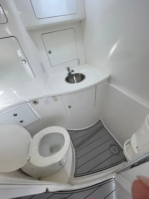 Slide: The Image of 2008 Intrepid Cuddy boat bathroom with toilet, sink, and storage cabinets. - 11