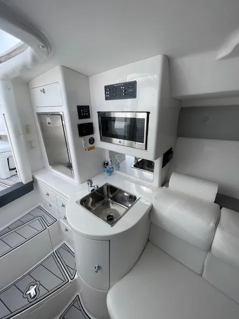 Slide: The Image of 2008 Intrepid Cuddy interior with modern kitchenette, sink, and microwave. - 12