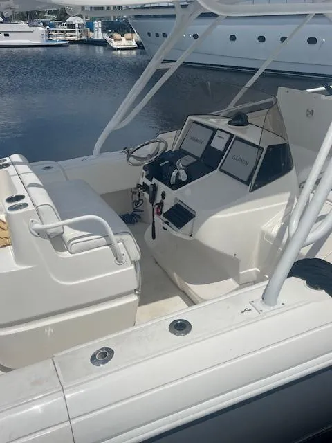 Slide: The Image of 2008 Intrepid Cuddy boat interior with steering console and seating, docked at marina. - 2
