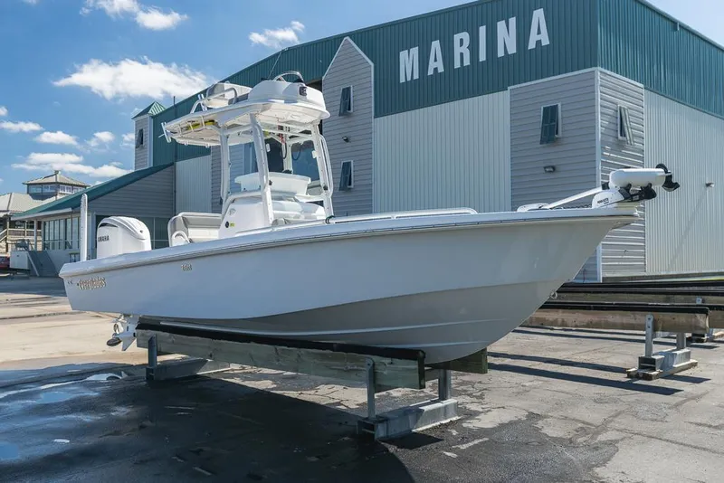 Slide: The Image of 2023 Everglades 243cc Sport Station boat at marina, clear sky background. - 1