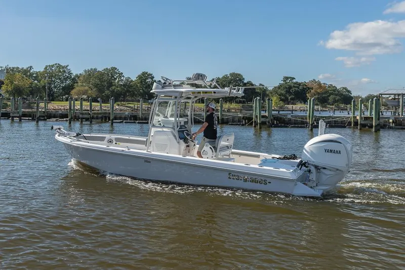 Slide: The Image of 2023 Everglades 243cc Sport Station boat cruising on a sunny day. - 12