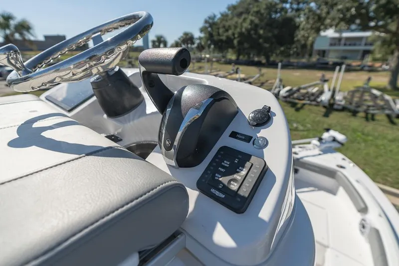 Slide: The Image of 2023 Everglades 243cc Sport Station boat controls with steering wheel and throttle. - 17