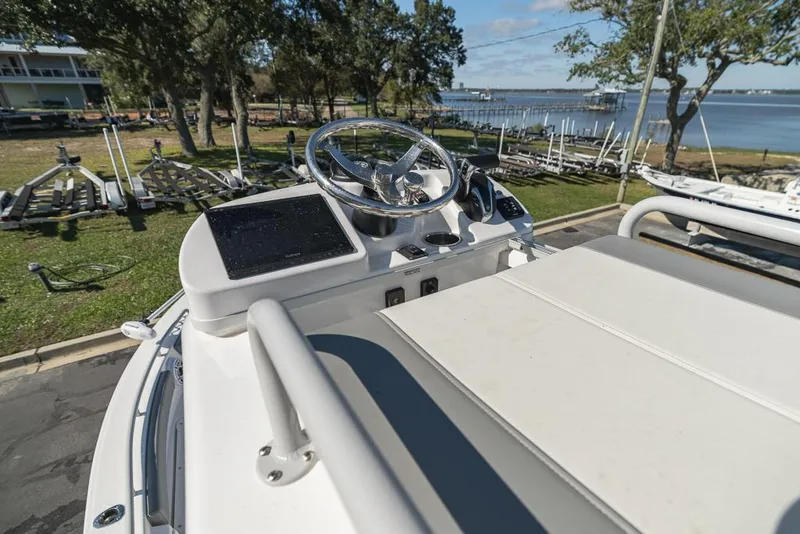 Slide: The Image of 2023 Everglades 243cc Sport Station boat helm with scenic waterfront view. - 21