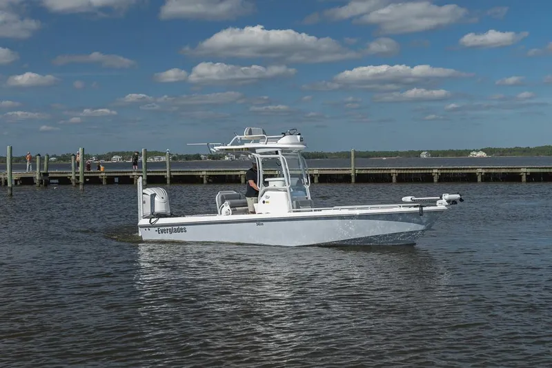 Slide: The Image of 2023 Everglades 243cc Sport Station boat on calm water under blue sky. - 4