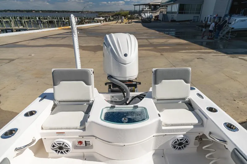 Slide: The Image of 2023 Everglades 243cc Sport Station boat interior with seating and motor at dock. - 41