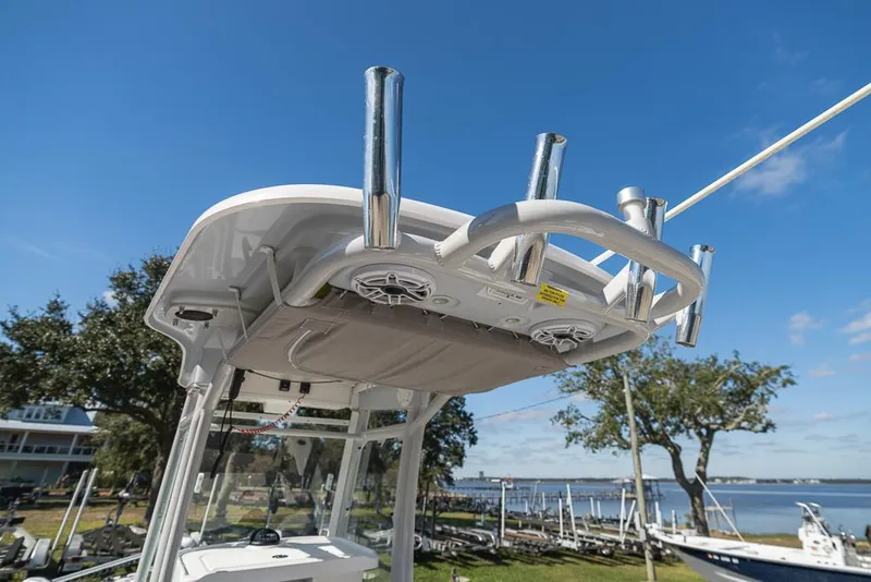 Slide: The Image of 2023 Everglades 243cc Sport Station boat with rod holders and speakers, docked by the water. - 45