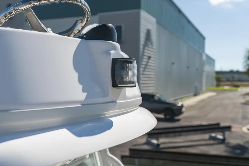 Slide: The Image of Close-up of 2023 Everglades 243cc Sport Station boat detail, with industrial building background. - 48