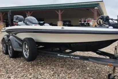 Slide: The Image of 2013 Ranger 520C boat on trailer, parked on gravel, near a building. - 3