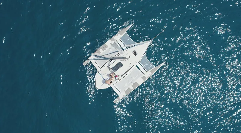 Slide: The Image of Aerial view of 2025 Corsair 760 trimaran sailing on clear blue ocean waters. - 8