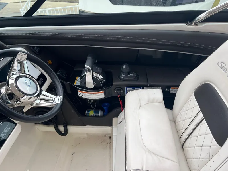 Slide: The Image of 2018 Sea Ray SLX 350 helm with steering wheel and white leather seat. - 10