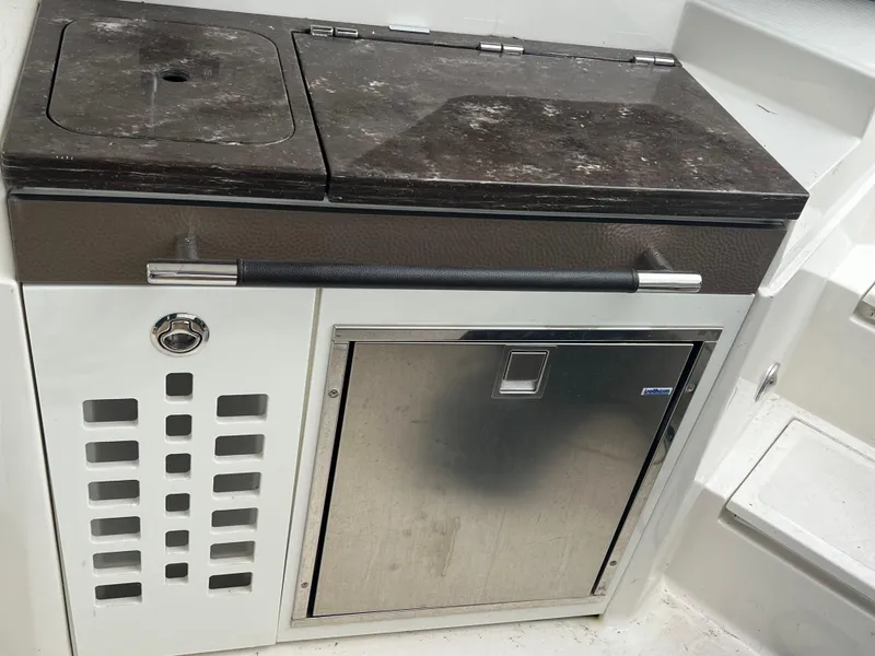 Slide: The Image of 2018 Sea Ray SLX 350 boat kitchenette with stainless steel fridge and countertop. - 14