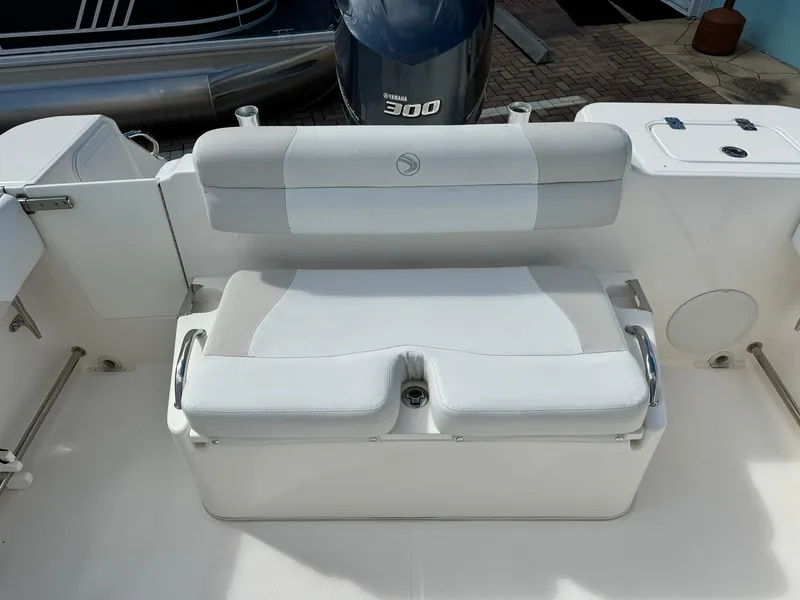 Slide: The Image of Edgewater 245 CX 2013 boat seating area with white cushioned bench and Yamaha 300 engine. - 11