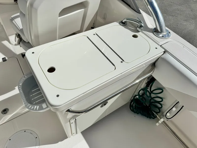 Slide: The Image of Edgewater 245 CX 2013 boat interior with storage compartment and coiled hose. - 16