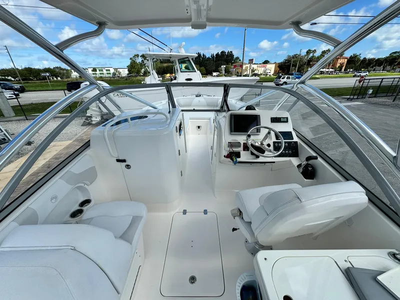 Slide: The Image of 2013 Edgewater 245 CX boat interior with white seating and modern dashboard. - 20