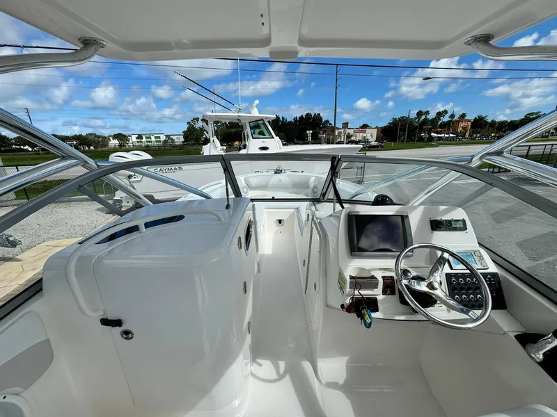 Slide: The Image of Edgewater 245 CX 2013 boat cockpit with steering wheel and dashboard controls. - 23